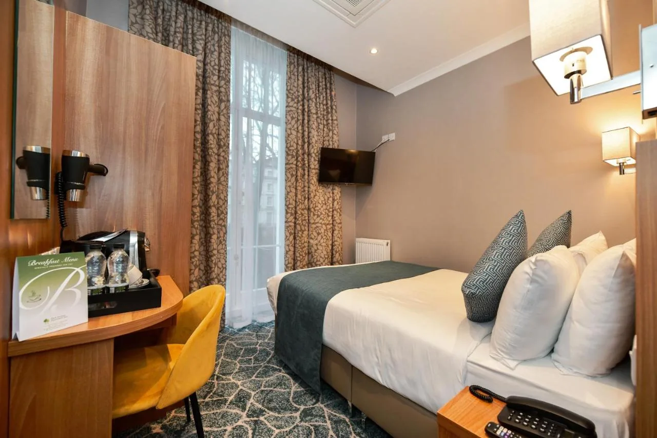 a hotel room with a bed and a desk at Park Avenue Bayswater Inn Hyde Park in London