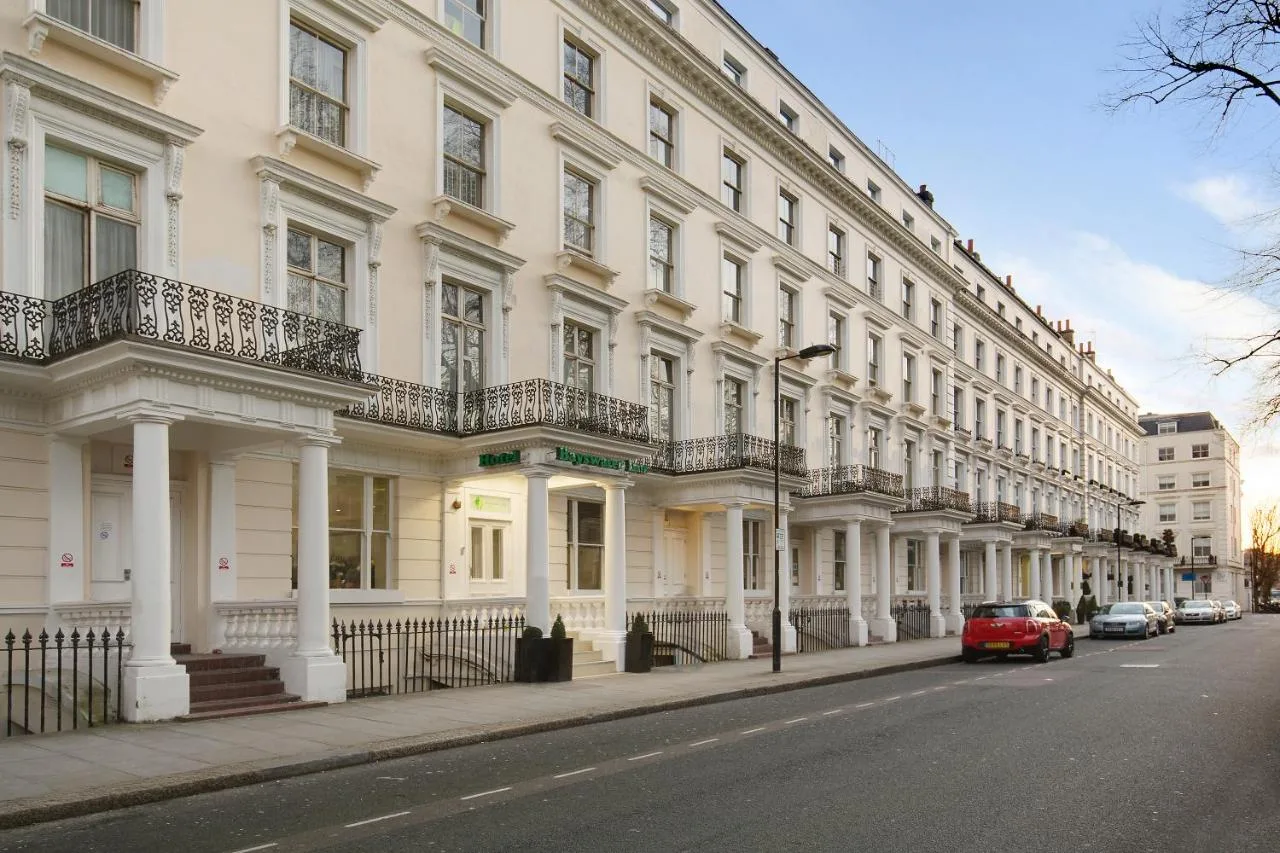a red car parked in front of a large white building at Park Avenue Bayswater Inn Hyde Park in London